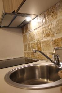 un fregadero en una cocina con una pared de piedra en Mountain Village House, en Cetinje