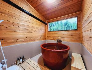 ein Badezimmer mit einer großen Badewanne in einem Holzzimmer in der Unterkunft リバティーリゾート久能山 
