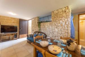 ein Wohnzimmer mit einem Tisch und einer Steinmauer in der Unterkunft Villa del Geco in Poggiardo