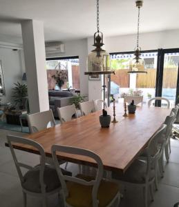 uma sala de jantar com uma mesa de madeira e cadeiras em Preciosa casa de lujo con piscina-150m de la playa em Almeria