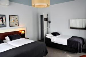 a bedroom with two beds and a tv on the wall at Apollo Hotel in Nijmegen