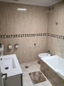 a bathroom with a sink and a tub and a toilet at Preciosa casa de lujo con piscina-150m de la playa in Almería