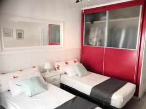 2 camas en una habitación con rojo y blanco en Preciosa casa de lujo con piscina-150m de la playa en Almería