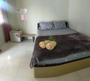 a bedroom with a bed with two towels on it at ณัฐวดี รีสอร์ท in Don Sak