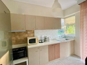 a small kitchen with a microwave oven and a stove at WildCalypso-2- Bedrooms Fully Equipped with Private Parking in Perea