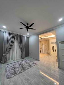 duży salon z wentylatorem sufitowym w domu w obiekcie Majestic Homestay - Pasir Puteh w mieście Pasir Puteh