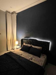 a bedroom with a bed with a black wall at Majestic Homestay - Pasir Puteh in Pasir Puteh