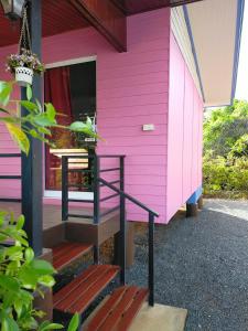 a pink house with stairs in front of it at ณัฐวดี รีสอร์ท in Don Sak