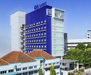 a blue building in the middle of buildings at Ibis Budget Bandung Asia Afrika in Bandung