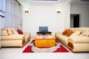 uma sala de estar com dois sofás e uma televisão em White Stone Apartments em Kigali