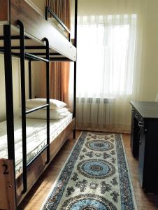 Zimmer mit 2 Etagenbetten und einem Teppich in der Unterkunft Salma Capsule Hostel in Bischkek