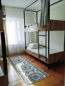 a bedroom with two bunk beds and a rug at Salma Capsule Hostel in Bishkek