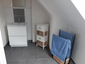 uma casa de banho com um lavatório e uma toalha azul em Cœur de ville, chambre confortable à louer en Bretagne em Saint-Méen-le-Grand