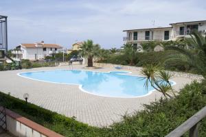 a large blue swimming pool in front of some houses at Parco Meridiana in Scalea