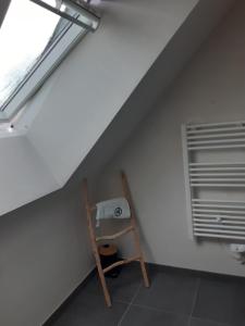 Zimmer im Dachgeschoss mit einer Leiter und einem Fenster in der Unterkunft Cœur de ville, chambre confortable à louer en Bretagne in Saint-Méen-le-Grand