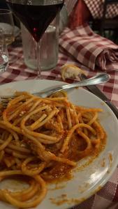 un plato de espaguetis en una mesa con una copa de vino en Sogno di mezza estate, en Torre Annunziata