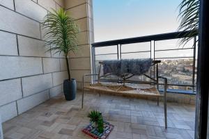 een balkon met een bank en een potplant bij J-Tower Apartments in Jeruzalem