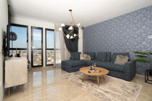 a living room with a blue couch and a table at J-Tower Apartments in Jerusalem
