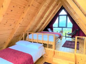 a room with two beds in a wooden attic at İnziva Bungalow1 in Ardeşen