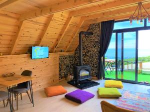 een kamer met een open haard en een tafel en stoelen bij İnziva Bungalow1 in Ardeşen