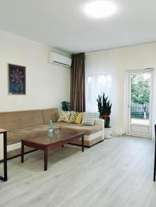 uma sala de estar com um sofá e uma mesa de centro em Salma Capsule Hostel em Bishkek