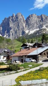 un bâtiment avec une montagne en arrière-plan dans l'établissement Ca' dello Scoiattolo, à Cortina dʼAmpezzo