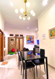 - une salle à manger avec une table et des chaises dans l'établissement Vila Kusuma Estate Batu, à Batu