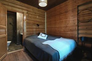 a bedroom with a bed in a wooden room at Levillenet Bearlodge at Levi city centre in Levi