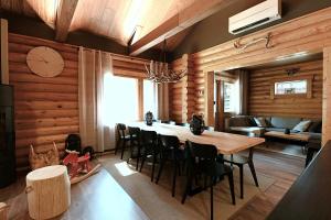 une salle à manger avec une grande table et des chaises en bois dans l'établissement Levillenet Bearlodge at Levi city centre, à Levi