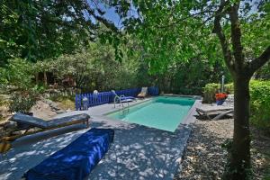 a swimming pool in a yard with a tree at Gîte Pina - Gîte avec piscine partagée in Lussan +10 photos