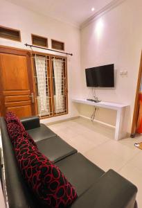 - un salon avec un canapé et une télévision dans l'établissement Vila Kusuma Estate Batu, à Batu