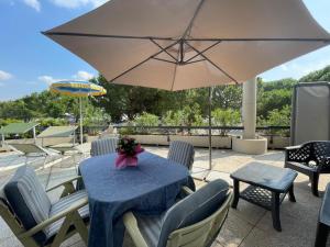 a table with chairs and an umbrella on a patio at garda fantasy paradise silver o gold in Desenzano del Garda