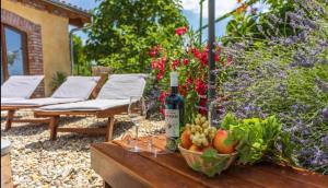 eine Flasche Wein und eine Schale Obst auf dem Tisch in der Unterkunft Hacienda in Grižane