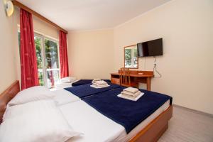 a bedroom with two beds and a desk and a television at Centinera Resort in Pula