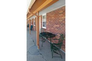 a patio with a table and chairs next to a brick wall at Love Hotels Murdo on Interstate 90 in Murdo