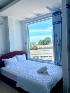 - une chambre avec un lit et une grande fenêtre dans l'établissement Isea Nha Trang Hotel, à Nha Trang