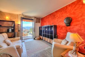 una sala de estar con paredes de color naranja y muebles blancos. en Miralago Lake View Outside Whirlpool - Happy Rentals en Ispra