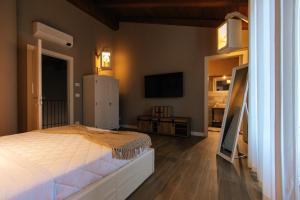 a bedroom with a bed and a flat screen tv at Agriturismo Agli ulivi in Saluzzo