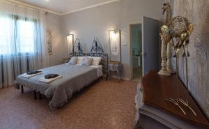 a bedroom with a bed and a dresser in it at Art b&b Gli Aironi in Pomposa