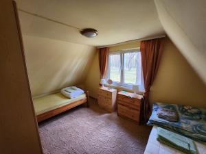 a small room with two beds and a window at Jak Tu Sielsko in Osiek