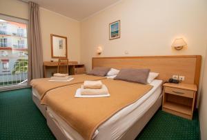 Habitación de hotel con 2 camas y toallas. en Centinera Resort en Pula
