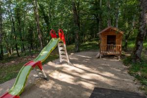 zwei Kinderspielgeräte vor einem Hundehaus in der Unterkunft Maison Linol in Beynac-et-Cazenac