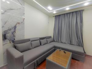 a gray couch in a room with a marble wall at Oznel Studio in Qadd el-Barûd