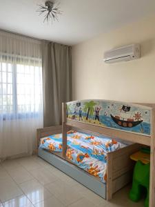 a bedroom with a bunk bed with a painting on the wall at Ionion Beachfront Villa in Ayia Napa