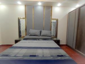a large bed in a room with two mirrors at Oznel Studio in Qadd el-Barûd