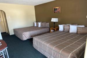 una camera d'albergo con due letti e una lampada di Love Hotels Murdo on Interstate 90 a Murdo