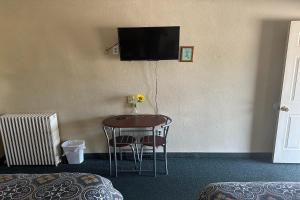 um quarto com uma mesa e uma televisão na parede em Love Hotels Murdo on Interstate 90 em Murdo