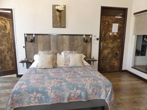 een slaapkamer met een groot bed met een houten hoofdeinde bij Hôtel de Charme Le Provence in Salon-de-Provence