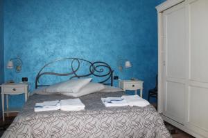 Un dormitorio azul con una cama con toallas. en B&B la Pavoncella, en Villamar