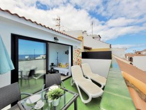 balkon z krzesłami i stołem na dachu w obiekcie Summer Breeze Penthouse w Puerto de la Cruz